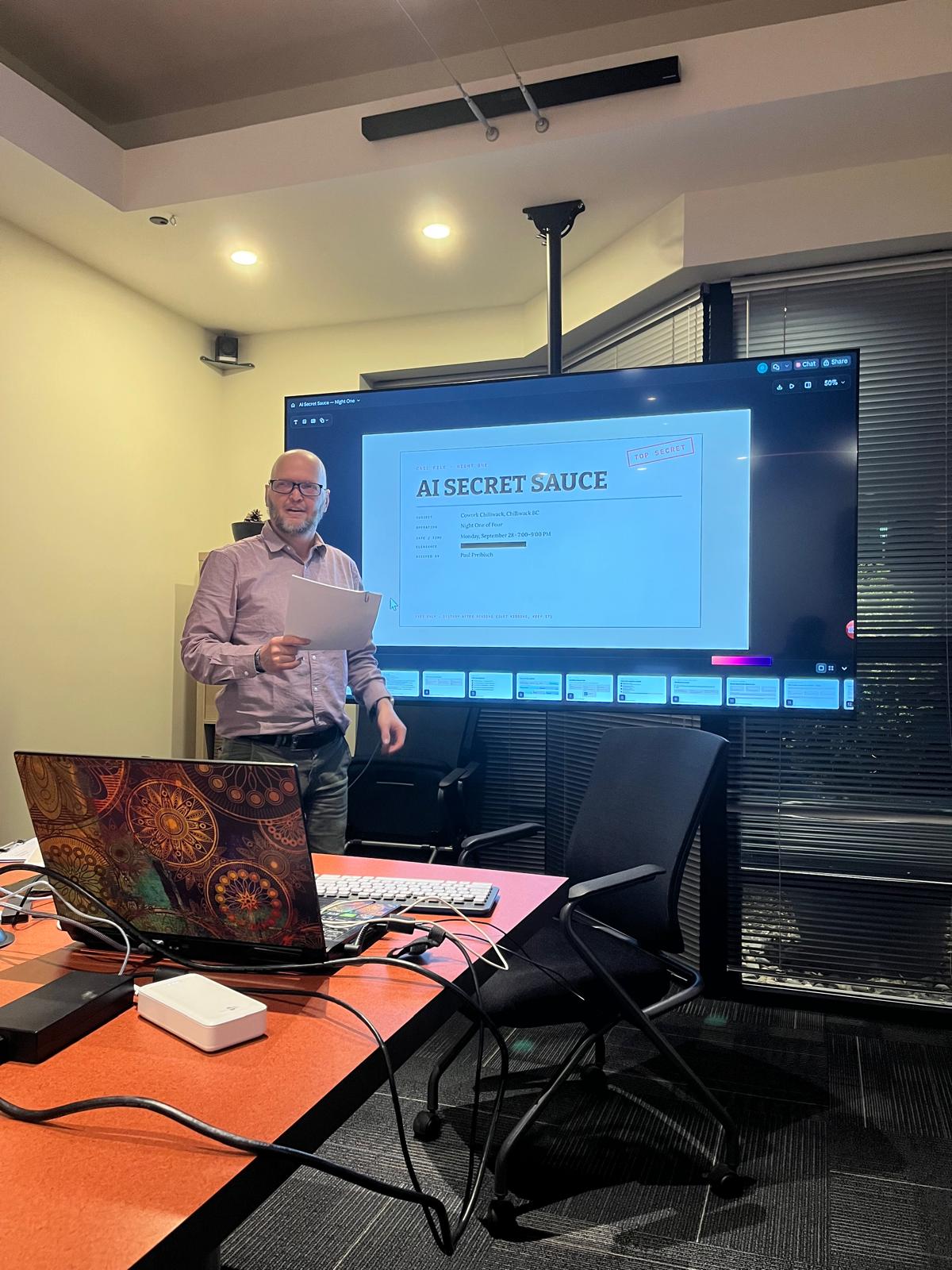Paul Preibisch opening Night One of AI Secret Sauce at Cowork Chilliwack, with the TOP SECRET title slide on the big screen